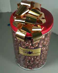 Chocolate Popcorn For A Crowd - Three and a half pounds of our fantastic gourmet chocolate covered caramel popcorn packaged in our large red clear canister that will put the crowd in an eating frenzy.  Wrapped in a gift bag with a large bow.  This is a unique treat and one of our most popular repeat gifts