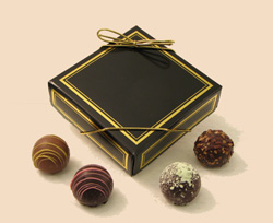 Old World Truffles | 4-piece box - A round delicate outer chocolate shell is filled with a rich dark chocolate ganache and flavored with the purest of ingredients to create a distinctive and memorable taste sensation.  Each piece is beautifully decorated.  Price includes printing of box with a minimum quantity of 50 boxes.  Packed in a four-piece box.